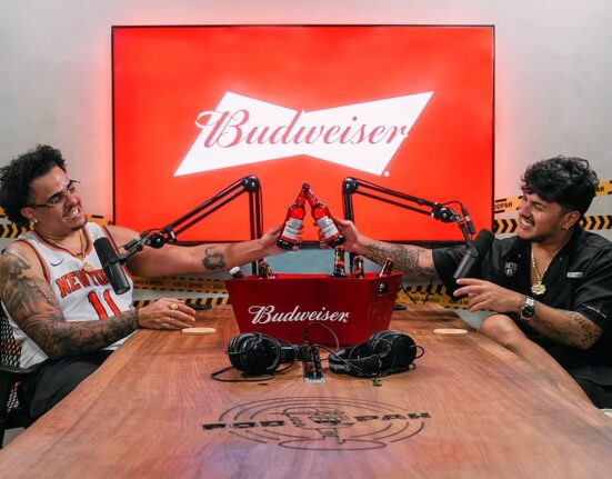 Igão (esq.) e Mítico, do podcast Podpah, em estúdio celebram ação com Budweiser; dulpa estará no Lollapalooza