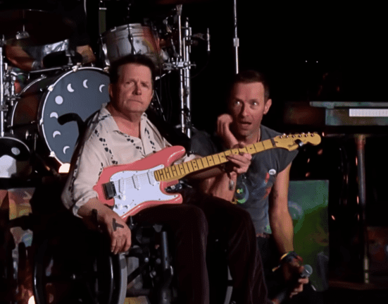 Ator Michael J. Fox (esq). e Chris Martin, vocalista do Coldplay, em show da banda no festival Glastonbury, no condado de Somerset, na Inglaterra | 29.jun.2024/Reprodução/BBC